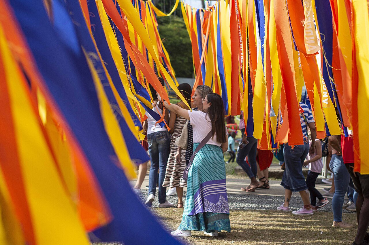 Visitantes del festival bajo cintas de colores.