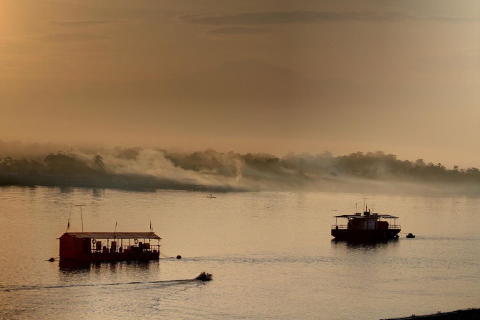 Barcas en un río cubierto de niebla.