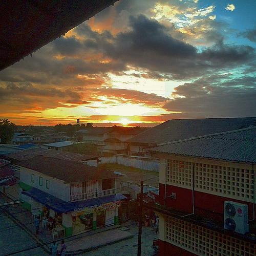Edificios junto al río bajo el cielo del atardecer.
