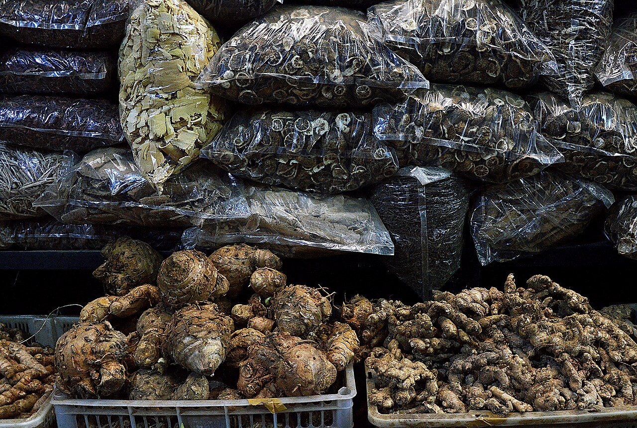 Cestas de rizomas bajo bolsas apiladas de material vegetal seco.