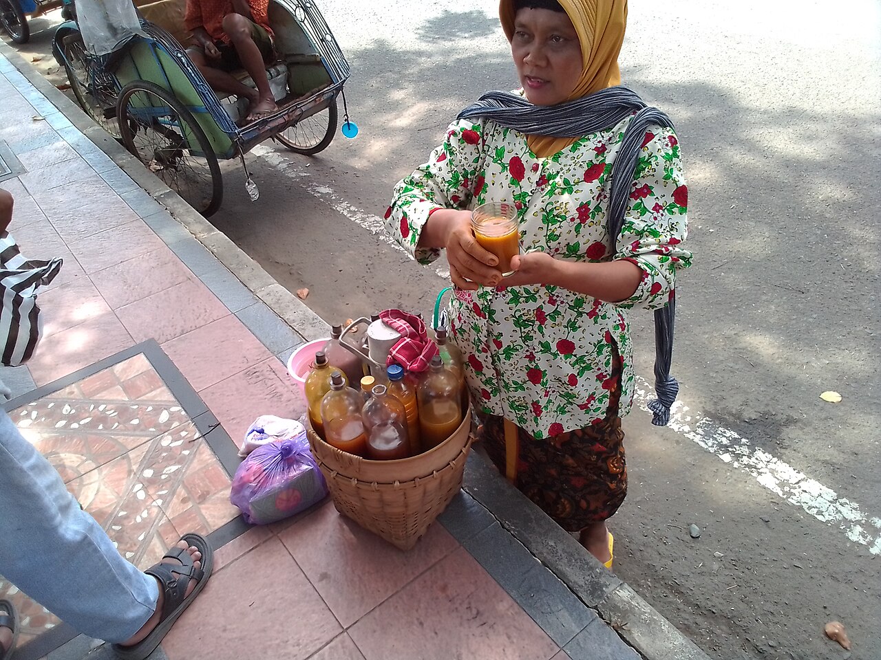 Una vendedora de jamu y sus botellas.