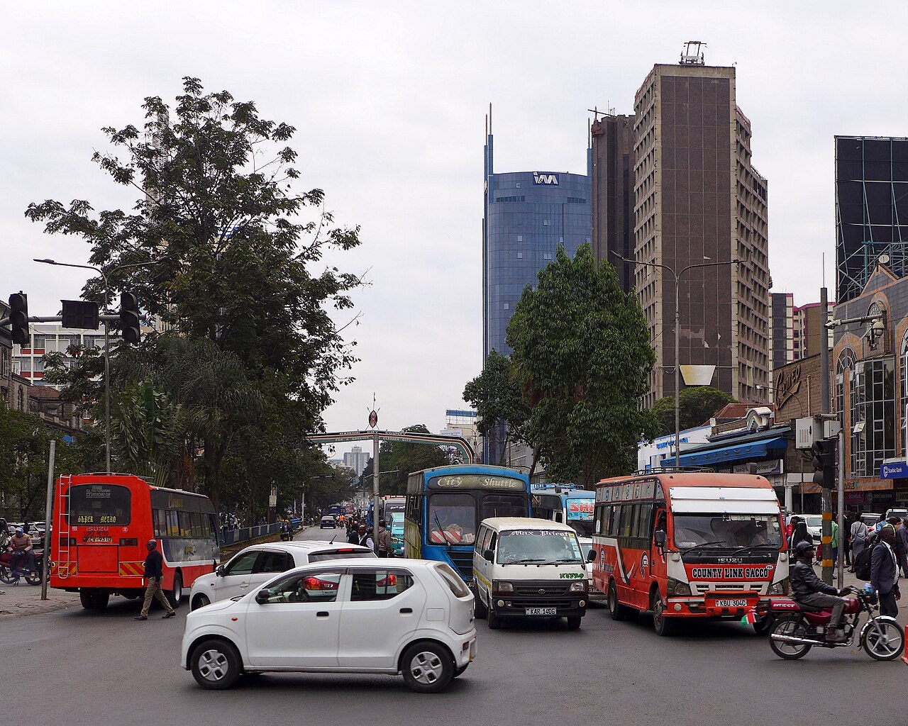 公交车、汽车、摩托车与行人穿行在繁忙的路口。
