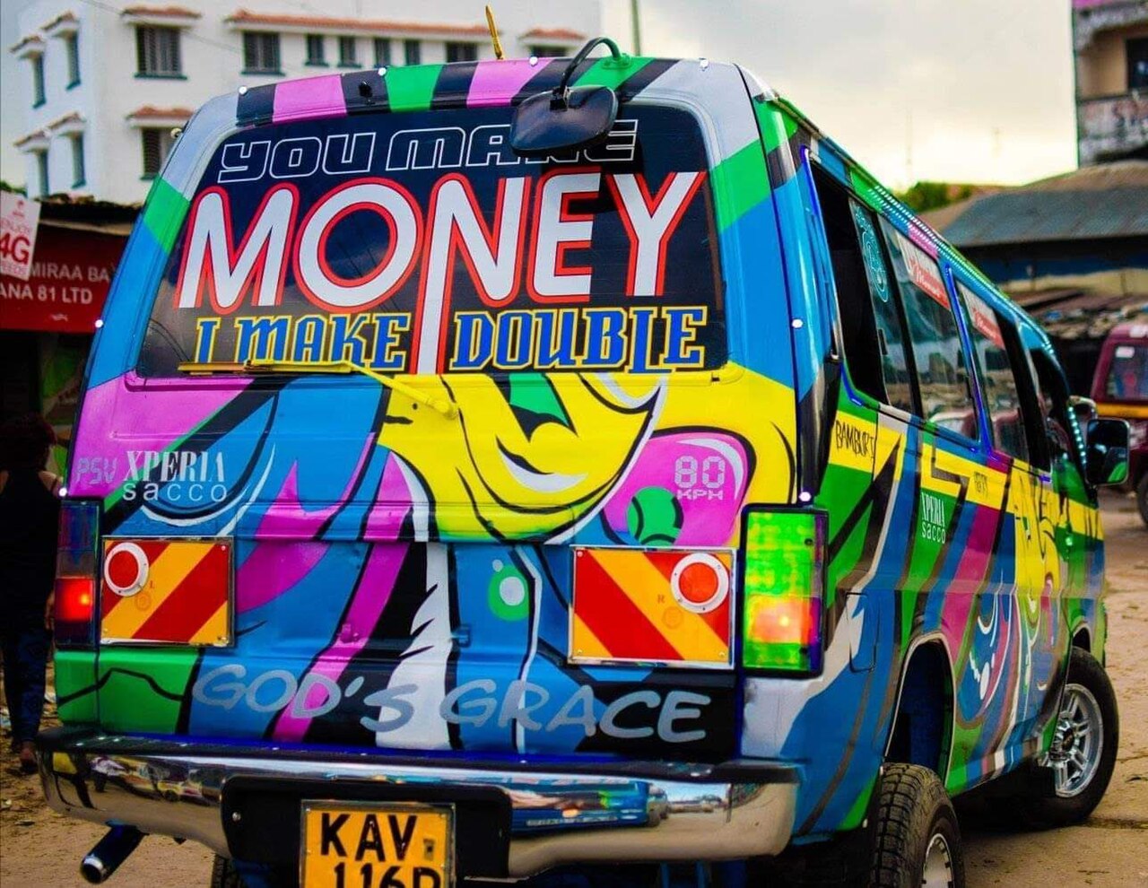 Rear of a vividly painted minivan with large slogans across its windows and body.