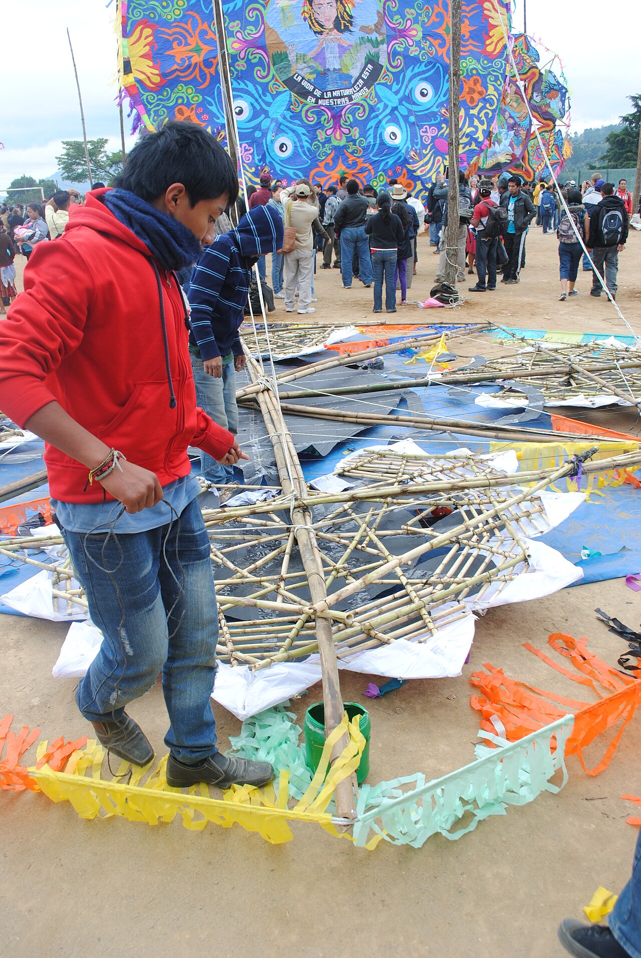 A participant beside the exposed supports of a large kite.