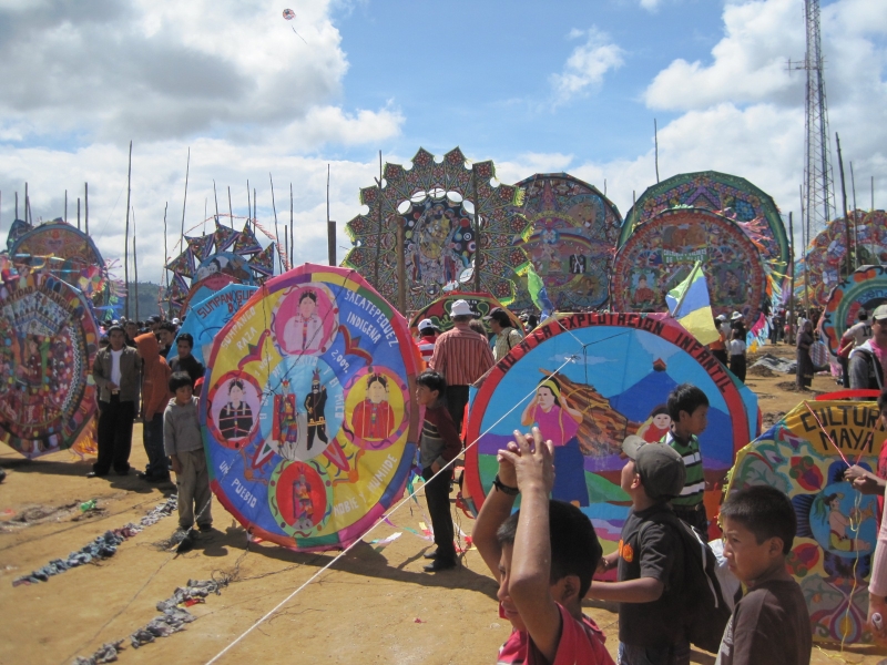 Des enfants parmi des cerfs-volants circulaires colorés sur le terrain du festival.