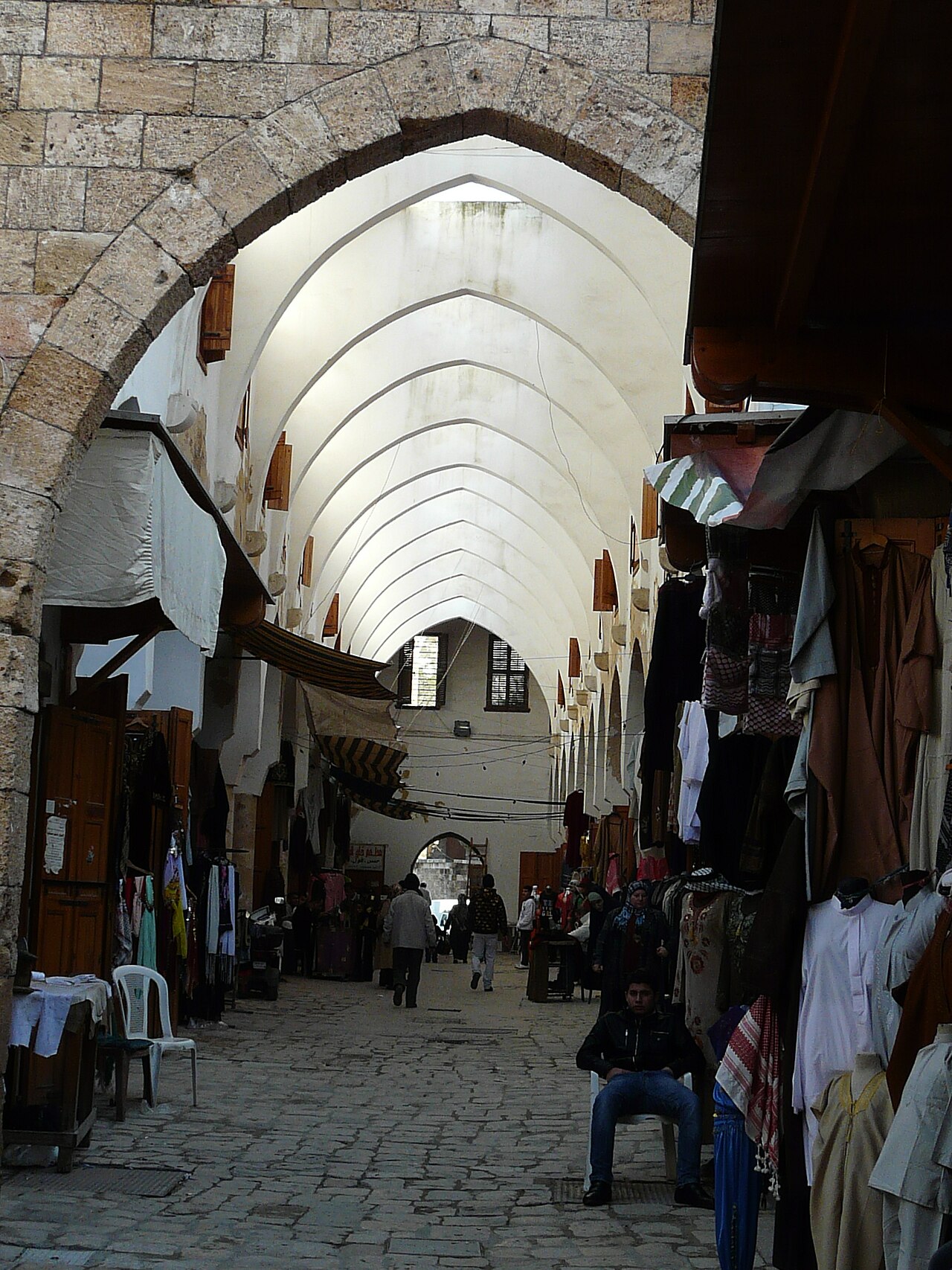 Des personnes et des boutiques dans un marché couvert.