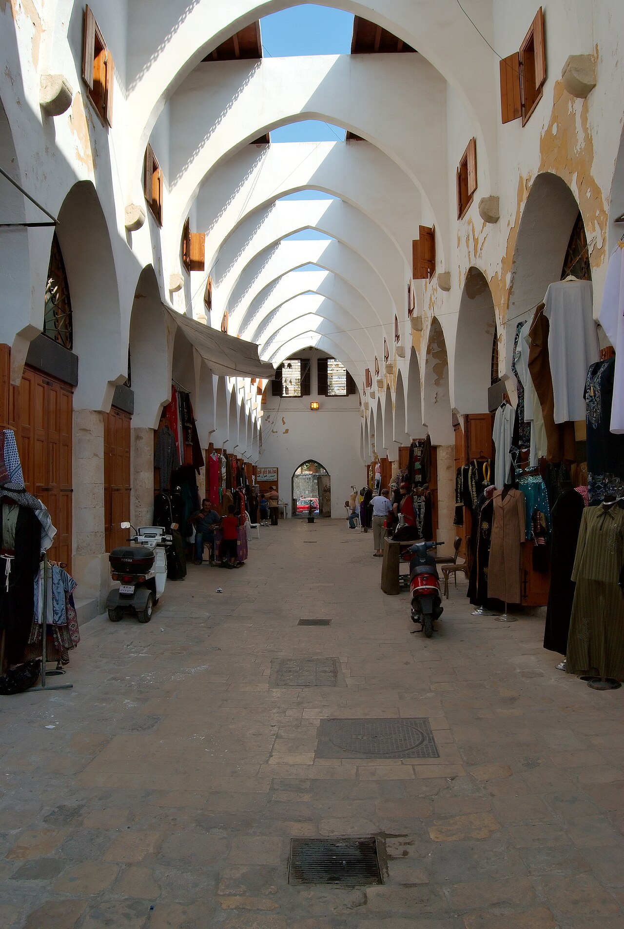 Des personnes et des boutiques dans un marché couvert.