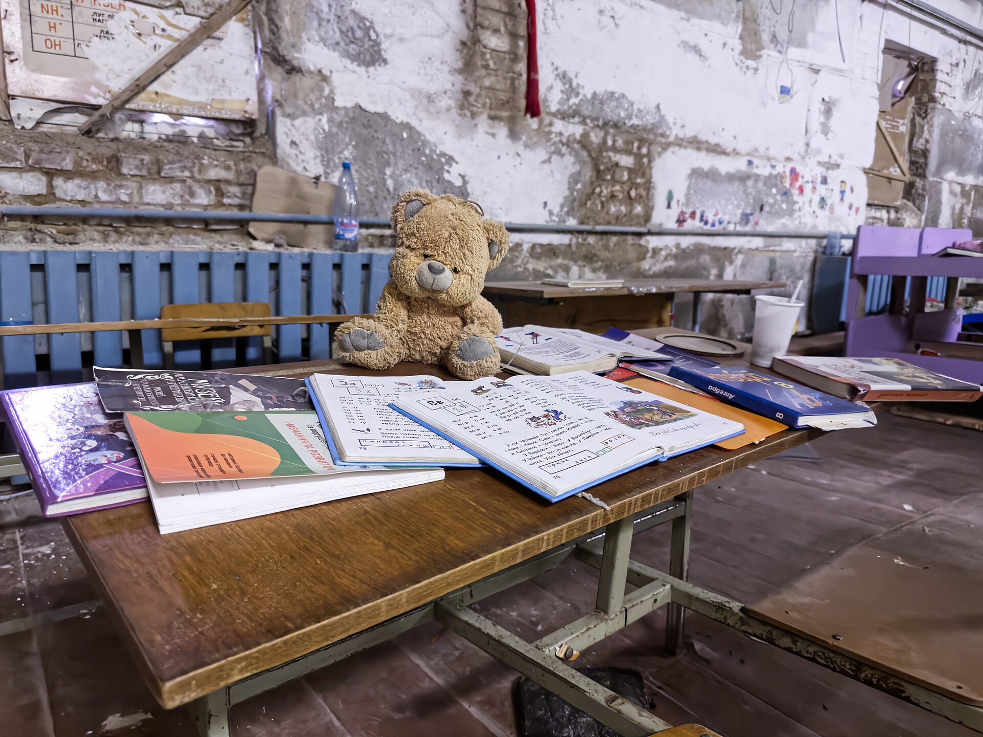 Books, a toy, and classroom furniture inside Yahidne’s damaged school, June 2023